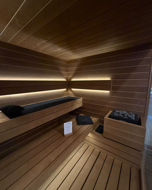 Interieur Auroom Lumina sauna met donker hout en indirecte LED-verlichting
