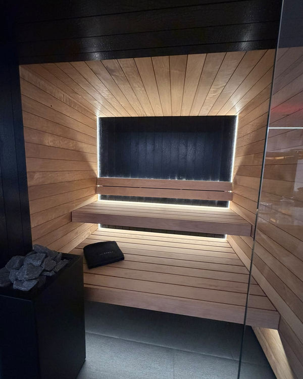 Interieur Auroom Vulcana sauna met gebrand hout achterwand en verlichte banken